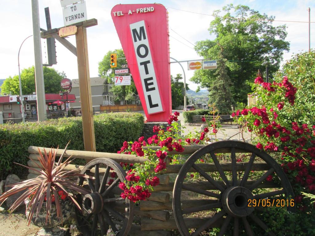 ein Zeichen für eine Noco-Tankstelle mit Blumen in der Unterkunft Tel-A-Friend Motel in Vernon