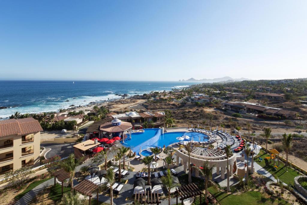 - une vue aérienne sur un complexe avec une piscine et l'océan dans l'établissement El Encanto All Inclusive Resort, à Cabo San Lucas