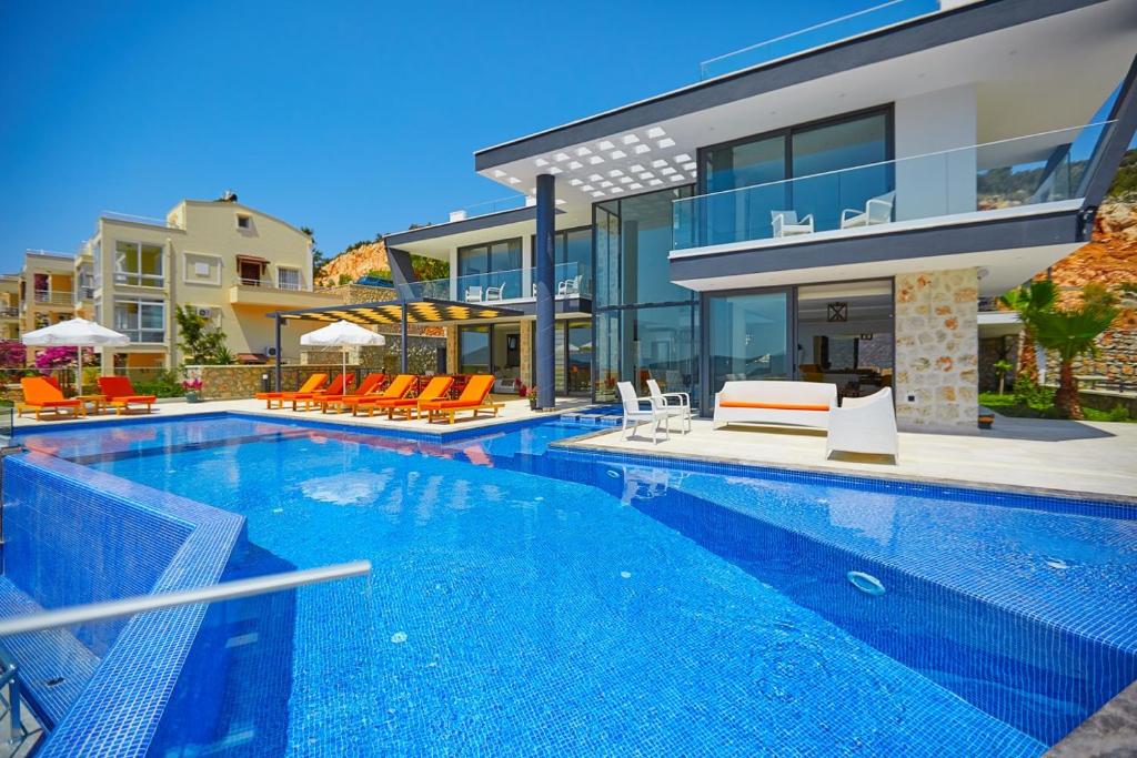 a large swimming pool in front of a house at Villa Unlimited 5 Bedroom Luxury Villa with Infinity Pool in Kalkan