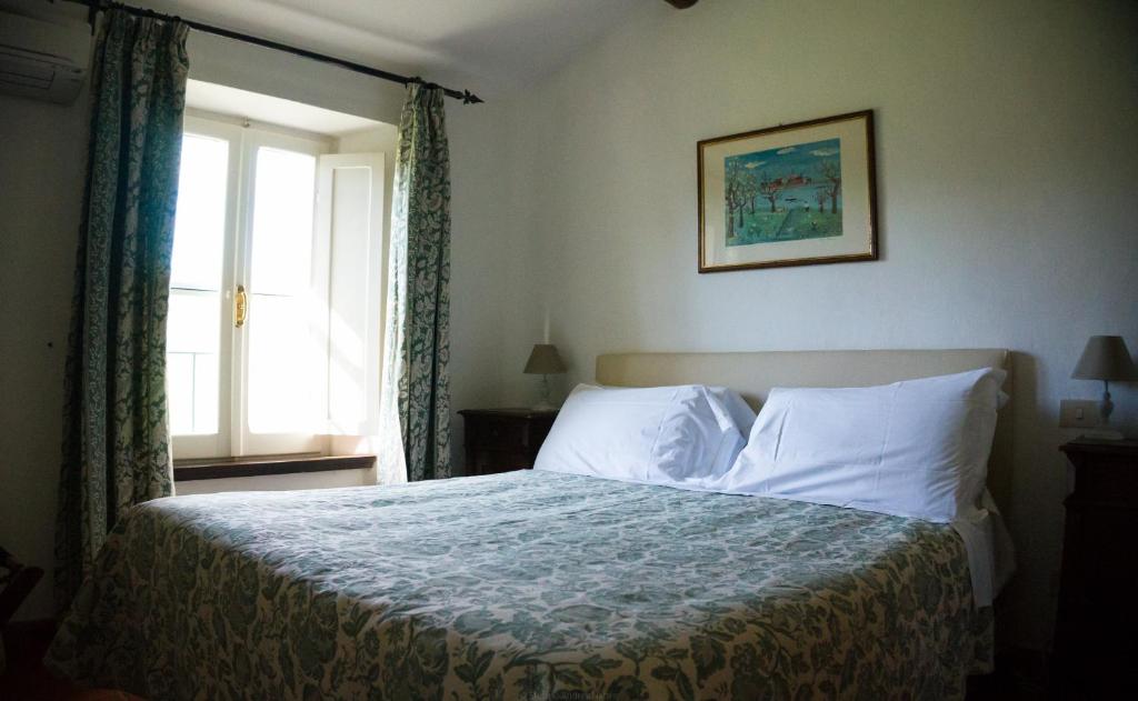 sypialnia z dużym łóżkiem i oknem w obiekcie Locanda Di Ansedonia - Ristorante GRIGL"io" w mieście Orbetello