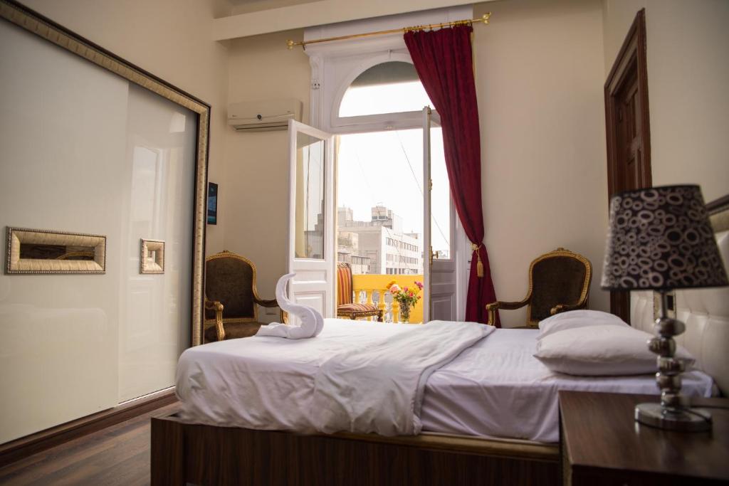 a bedroom with a bed and a large window at Hotel Grand Royal Cairo in Cairo