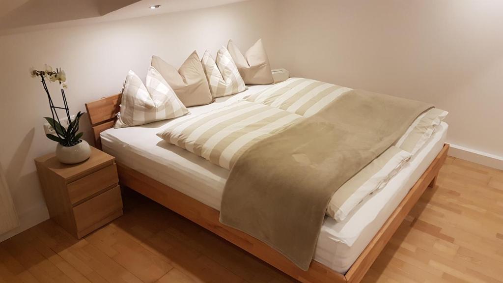 a large bed with white sheets and pillows at Apartment Bergverliebt in Mieming