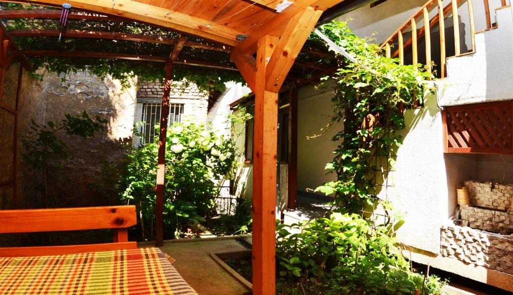 un patio con pérgola de madera y un banco en Apartments Dino, en Sarajevo