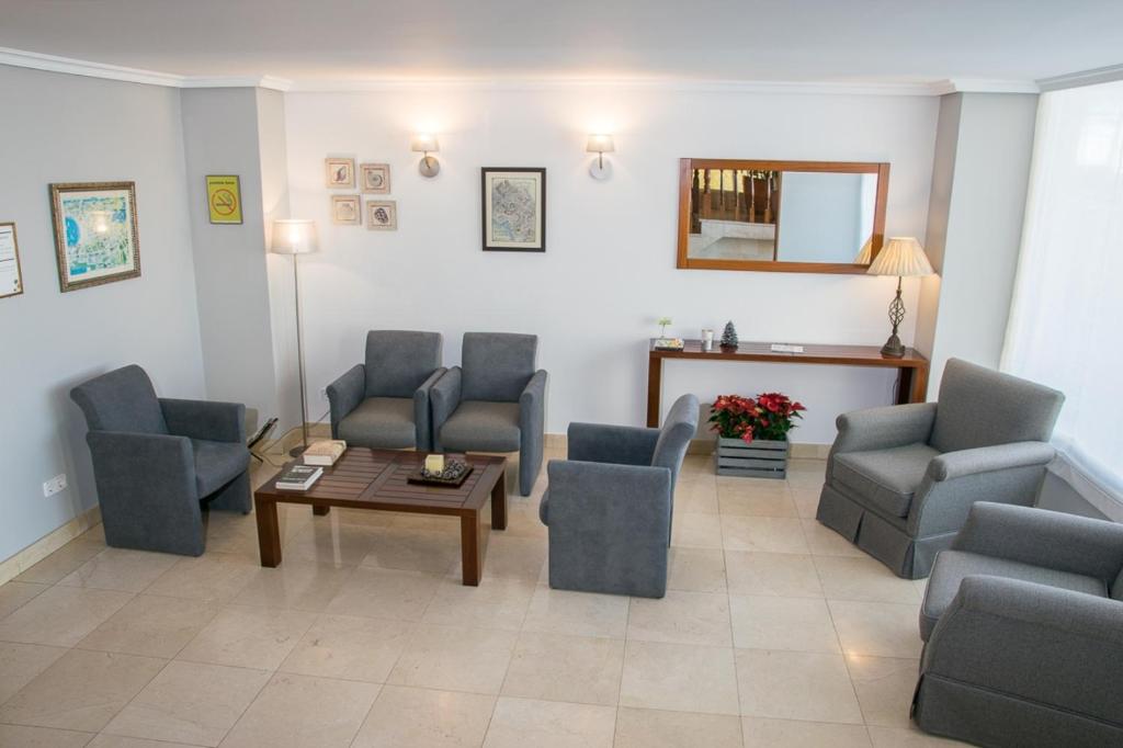 ア・コルーニャにあるHotel Brisaの椅子、テーブル、鏡付きの待合室