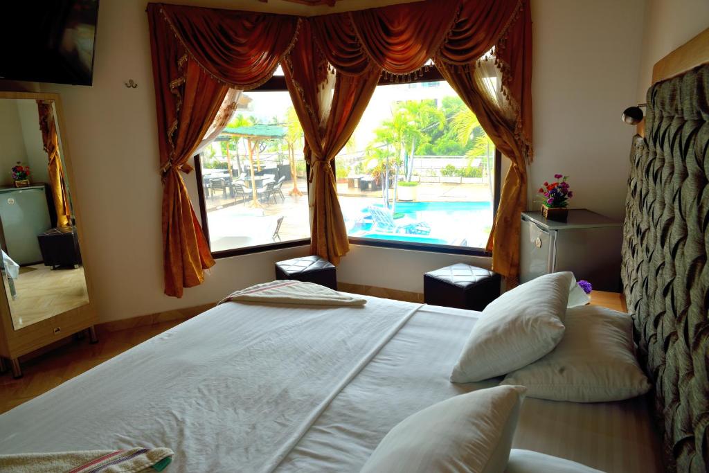 a bedroom with a bed and a large window at Encanto Hotel Boutique in Santa Marta