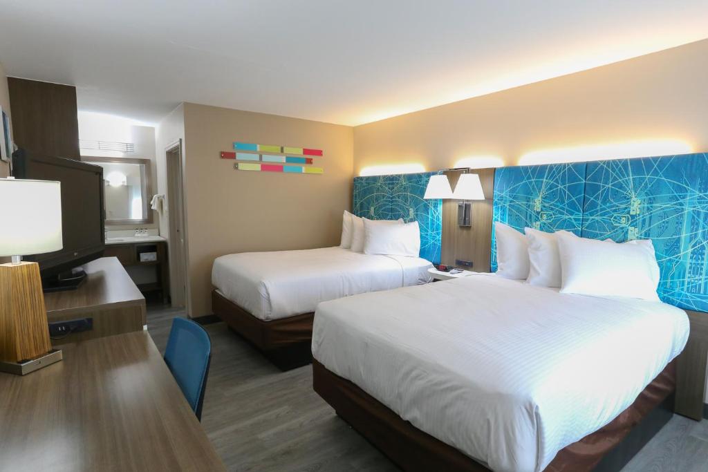 ein Hotelzimmer mit 2 Betten und einem TV in der Unterkunft Oasis Inn in Beaufort