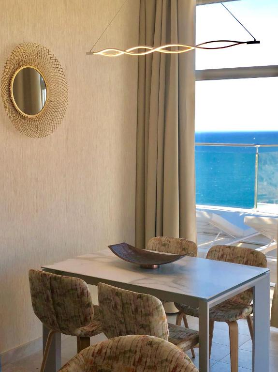 a dining room with a table and chairs and a window at Holiday Club Jardin Amadores in Amadores