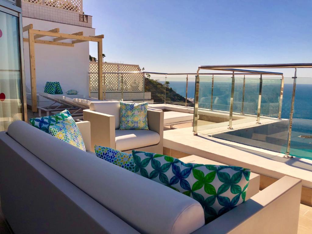 a balcony with couches and a view of the ocean at Holiday Club Jardin Amadores in Amadores
