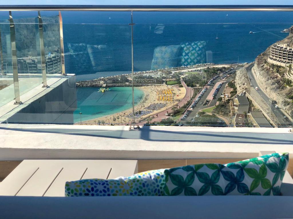 a window with a view of a city and the ocean at Holiday Club Jardin Amadores in Amadores