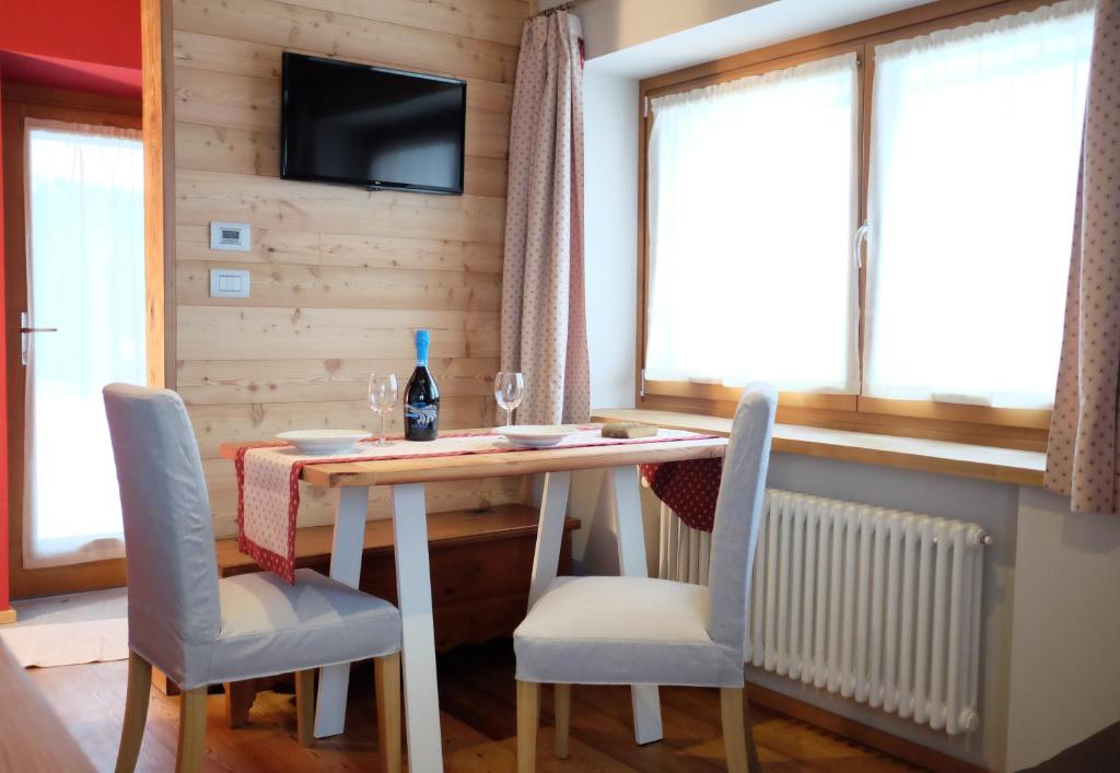 a dining room with a table and chairs and a television at Casa Monet in Saint Vincent