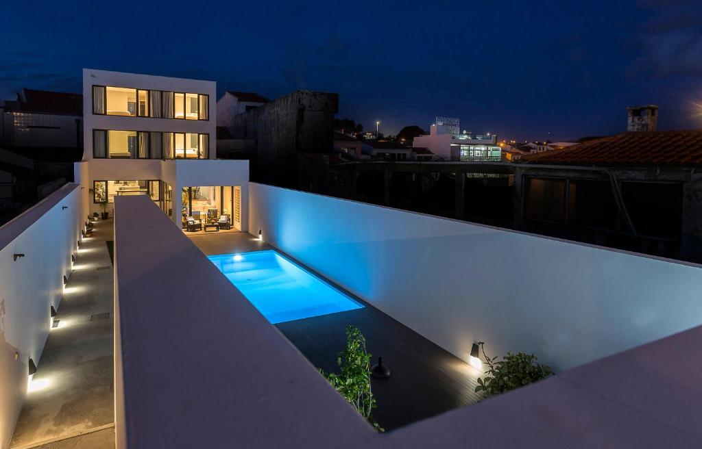 a swimming pool on the side of a building at night at Praia de Santos, Exclusive Villa, Açores in Ponta Delgada