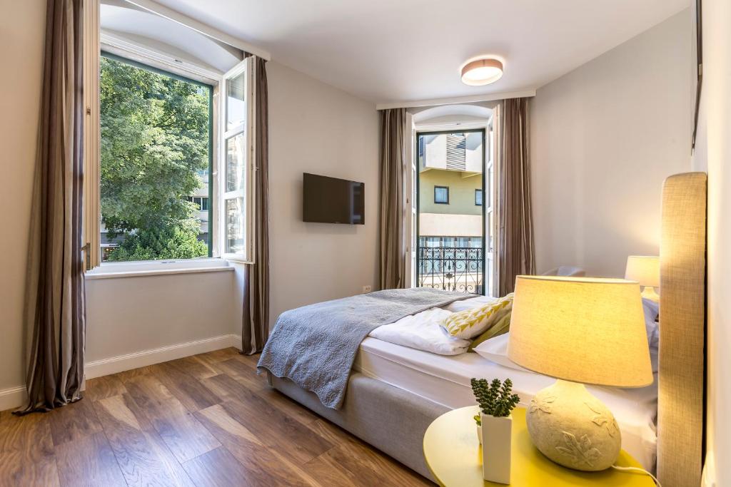 1 dormitorio con 1 cama y 2 ventanas en Piano Nobile Rooms, en Split
