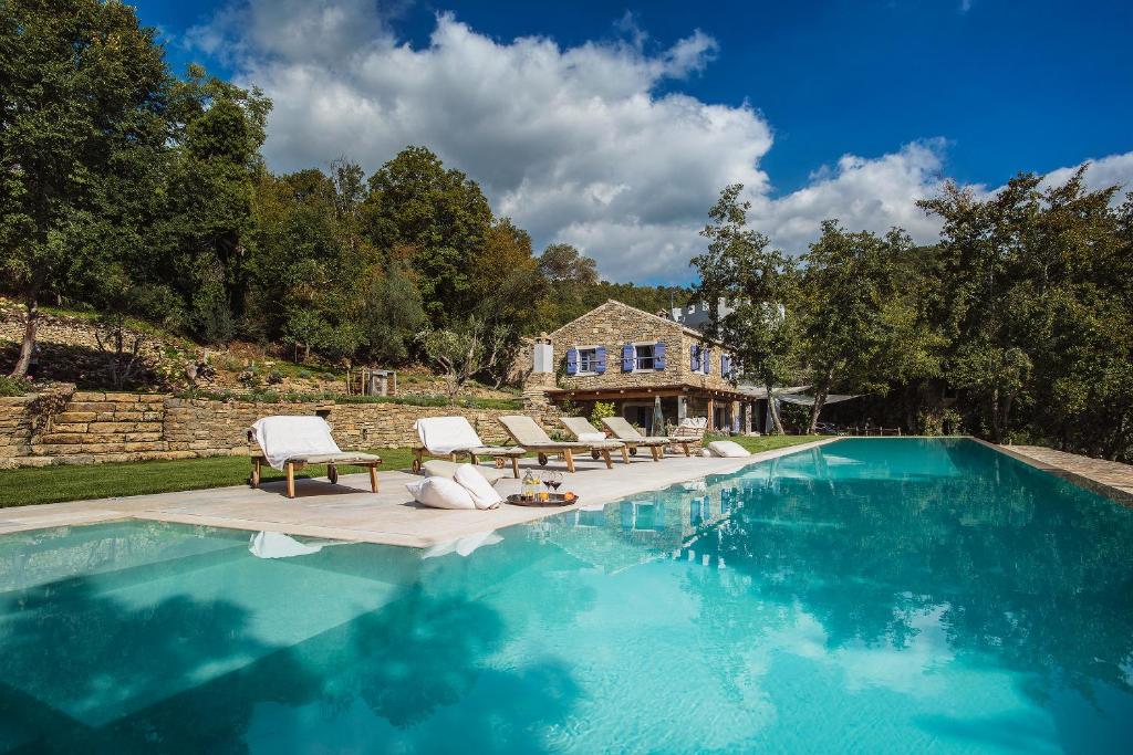 a swimming pool with two lounge chairs and a house at Villa Torrecorta in Grožnjan