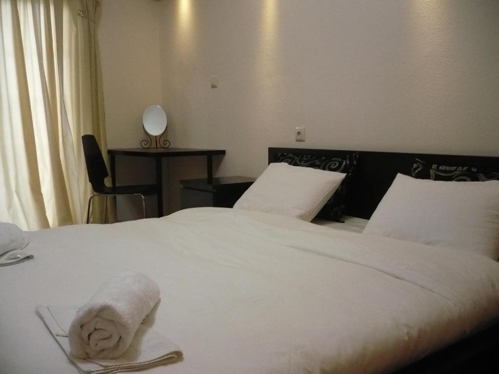 Una habitación de hotel con 2 camas y una toalla. en Alexandros Hotel en Leptokarya