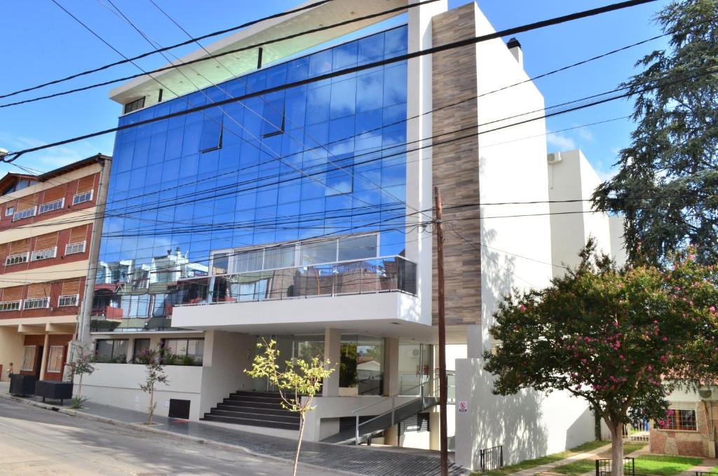 um edifício de vidro numa rua da cidade em Edificio PRISMA I em Villa Carlos Paz