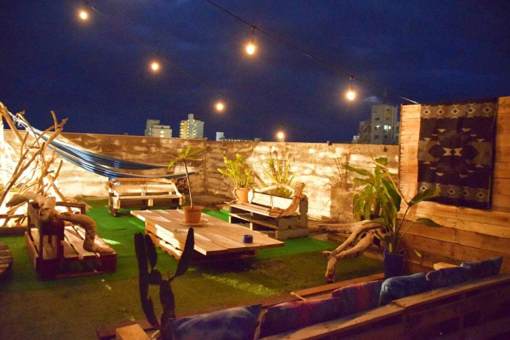 a patio with a hammock on a rooftop at night at guest house Holoholo Ishigakijima in Ishigaki Island