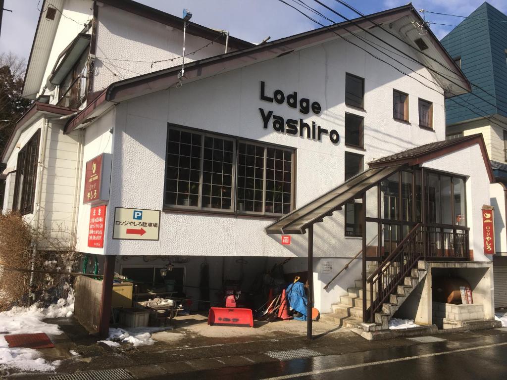 un gran edificio blanco con gente parada fuera de él en Lodge Yashiro, en Yuzawa