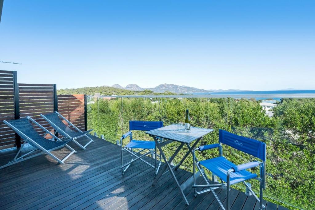 een tafel en stoelen op een terras met uitzicht op de oceaan bij Freycinet Panorama in Coles Bay