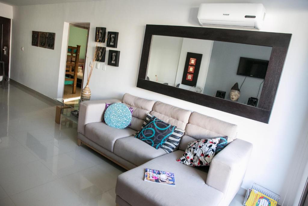sala de estar con sofá y espejo en Apartamento Moderno con Piscina Rodadero, en Santa Marta