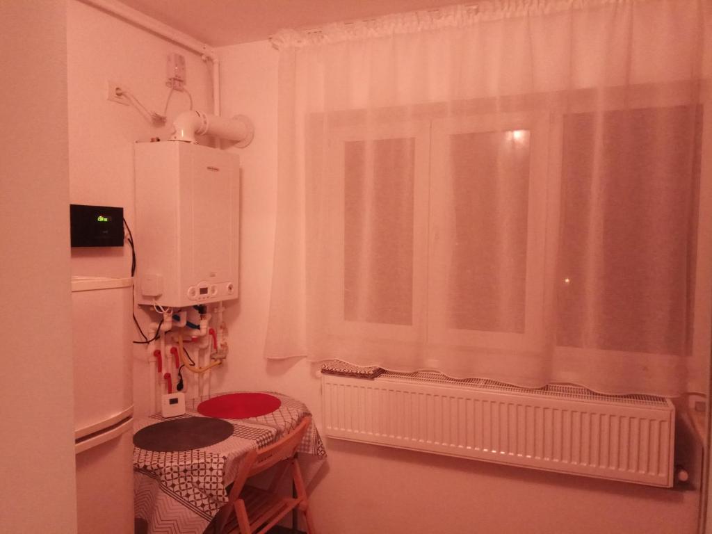 a kitchen with a window and a table and a refrigerator at Apartament Rema in Constanţa