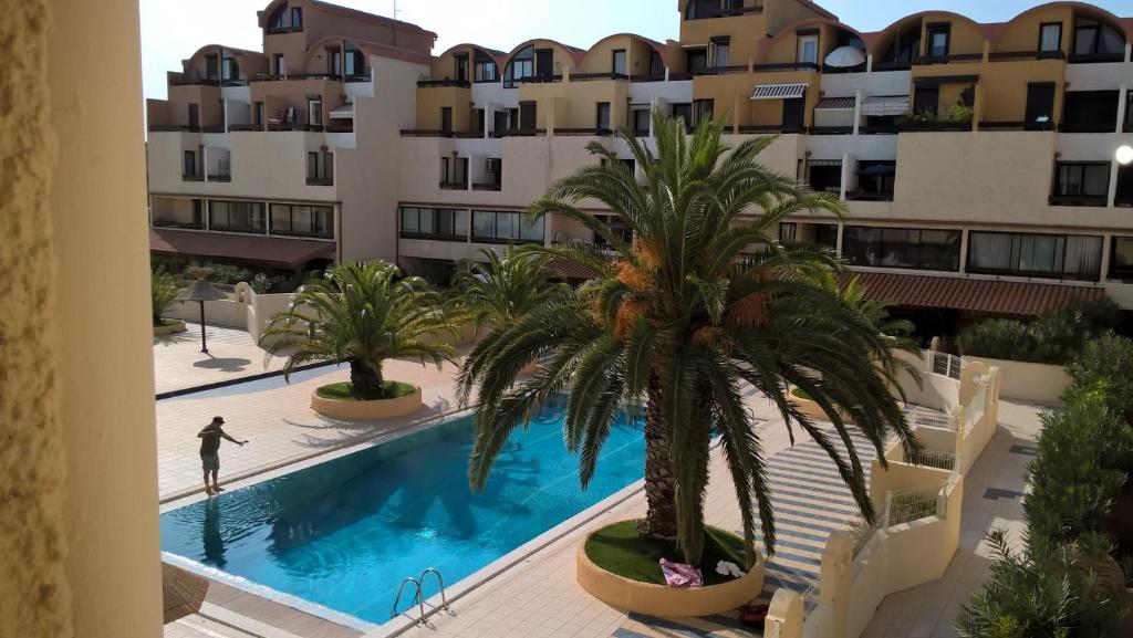 a man is playing in a swimming pool in a building at Résidence les dromadaires in Gruissan