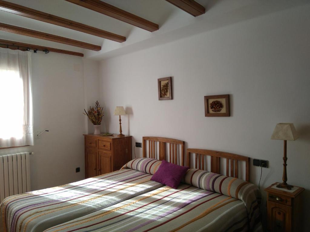 a bedroom with a bed with a striped comforter at Casa la Era in Nogueruelas