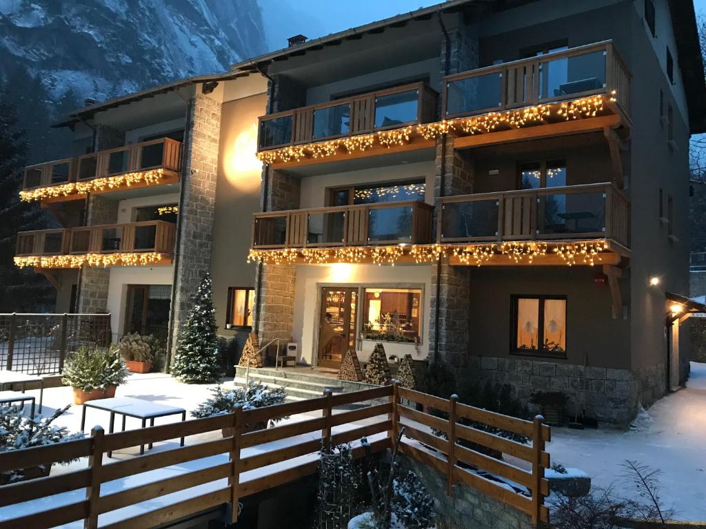un edificio con luces de Navidad en la nieve en Hotel Le Cime, en Val Masino