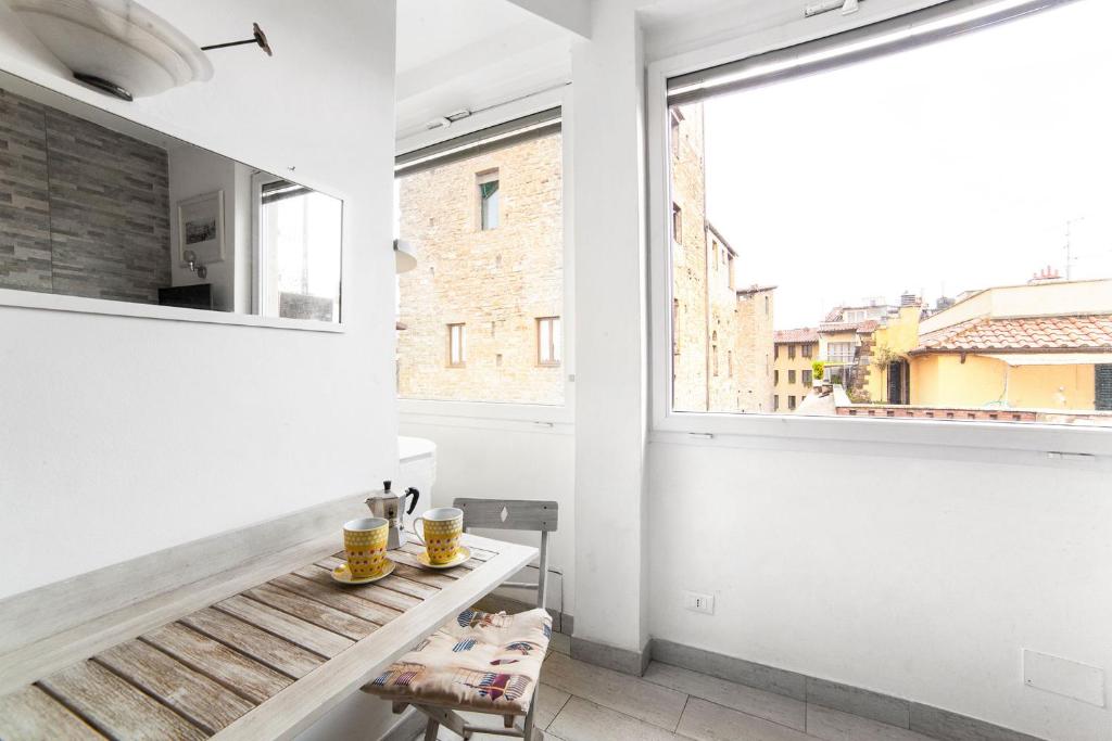a white room with a bench and a window at Studio Flat Ponte Vecchio in Florence