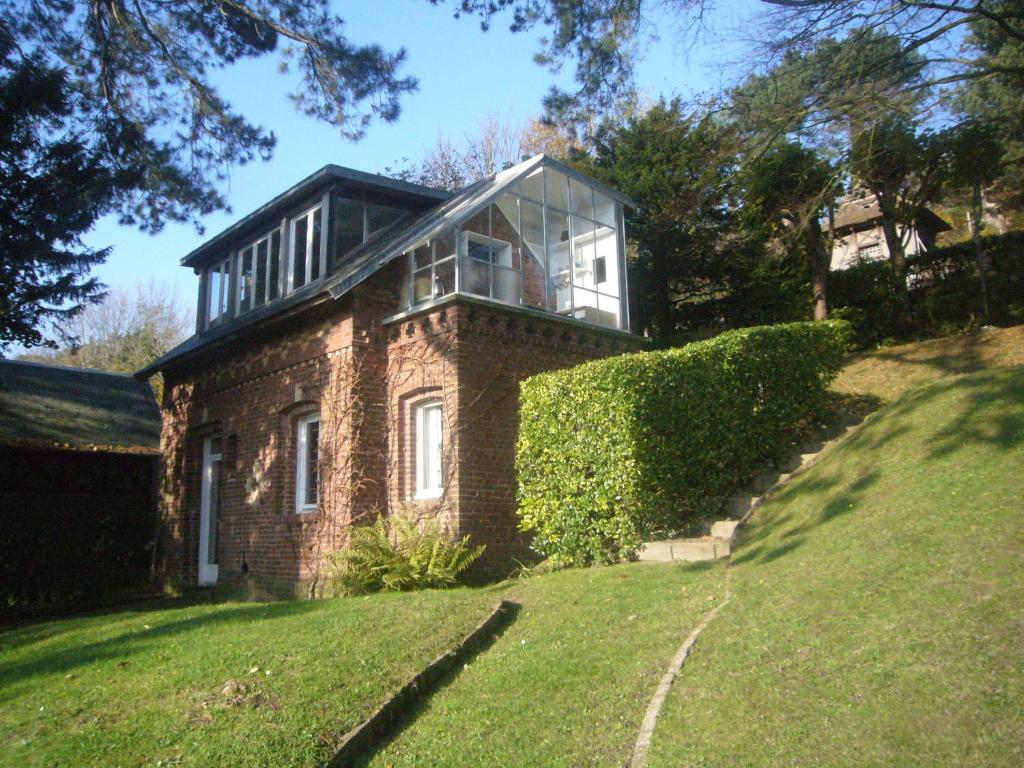 a brick house with a window on top of a hill at Gîte La Petite Maison in Étretat