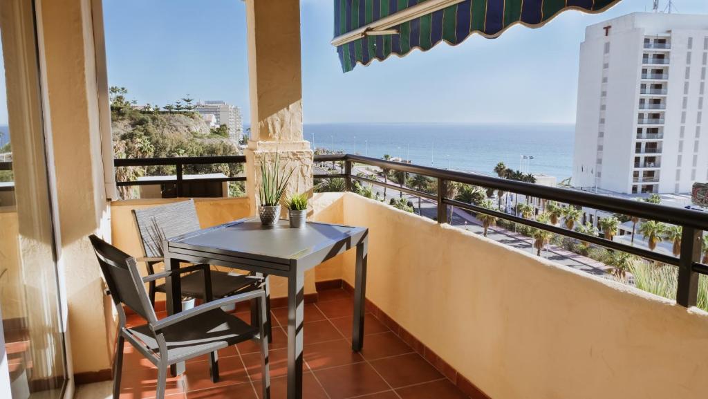 een balkon met een tafel en stoelen en uitzicht op de oceaan bij Casinomar Frente al Mar in Benalmádena