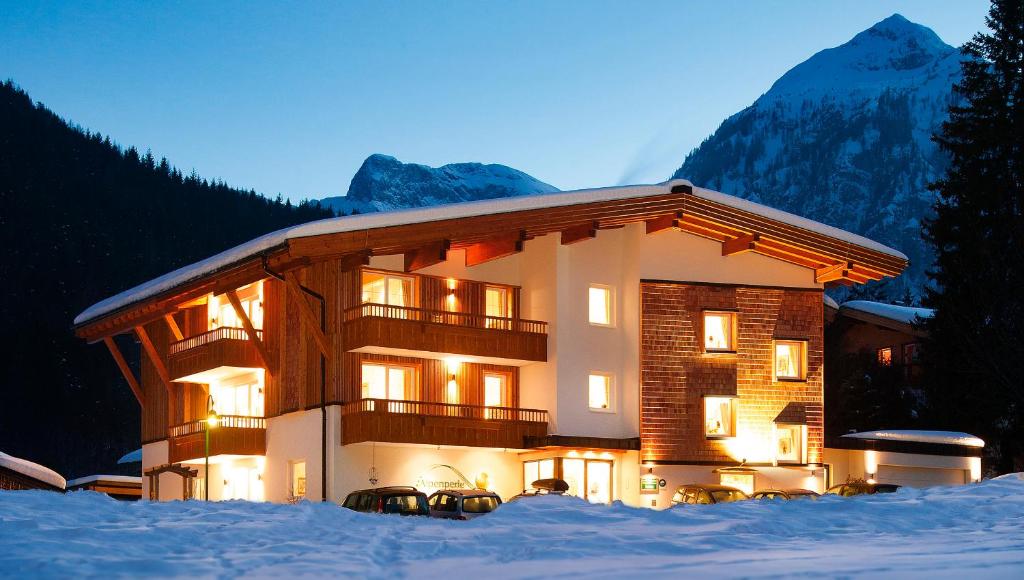 a large building with snow in front of it at Alphaus Aparthotel in Pertisau