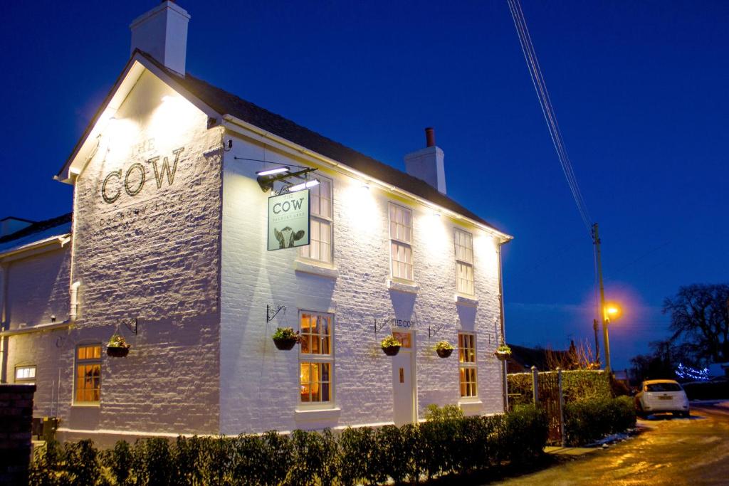 a white building with lights on the side of it at The Cow Dalbury in Dalbury Lees