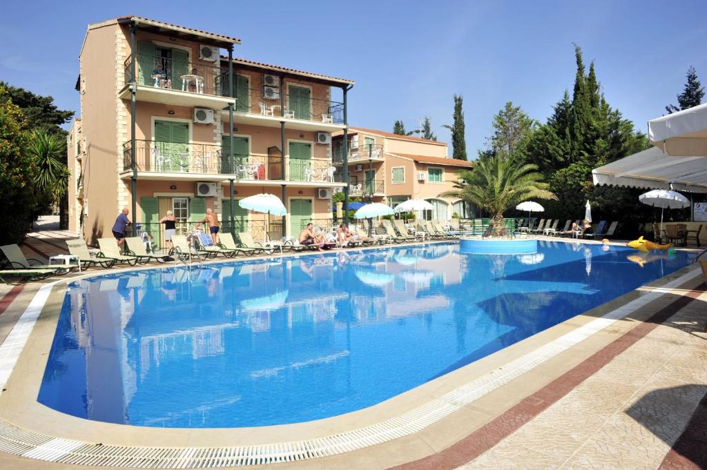 uma grande piscina em frente a um edifício em Philippos Hotel em Kassiopi