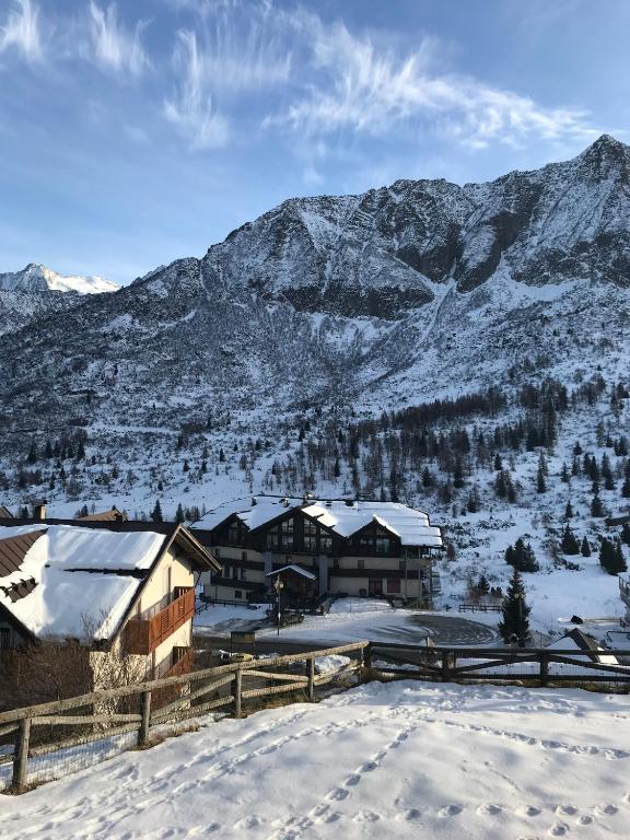 a lodge in the snow with mountains in the background at TONALE 3 in Passo del Tonale