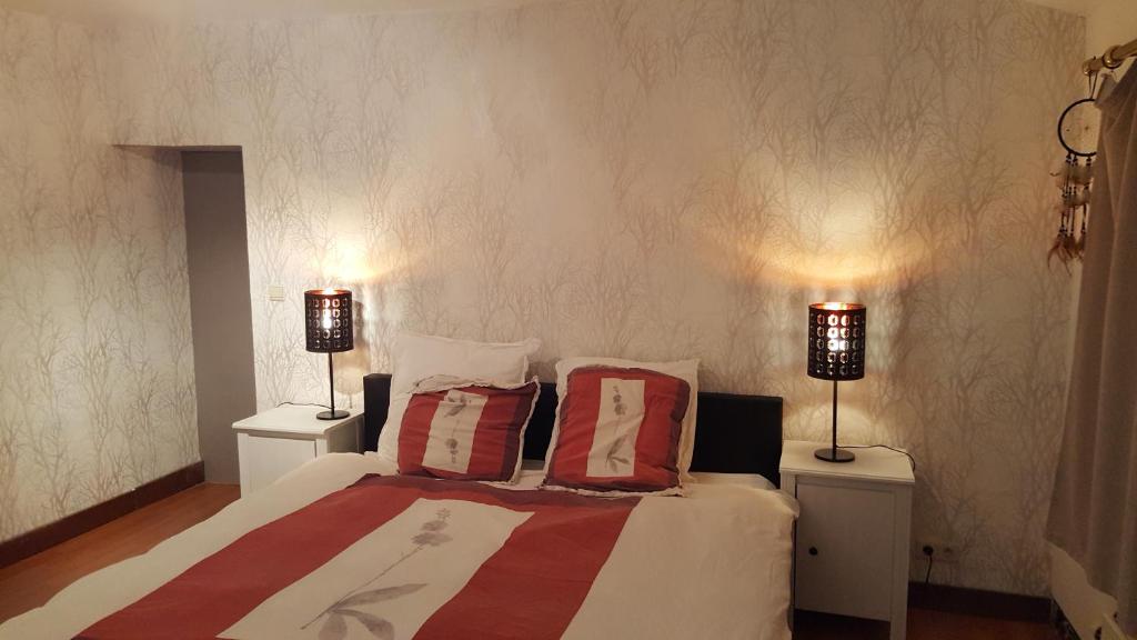 a bedroom with a bed with two lamps on two tables at Au calme in Marchin