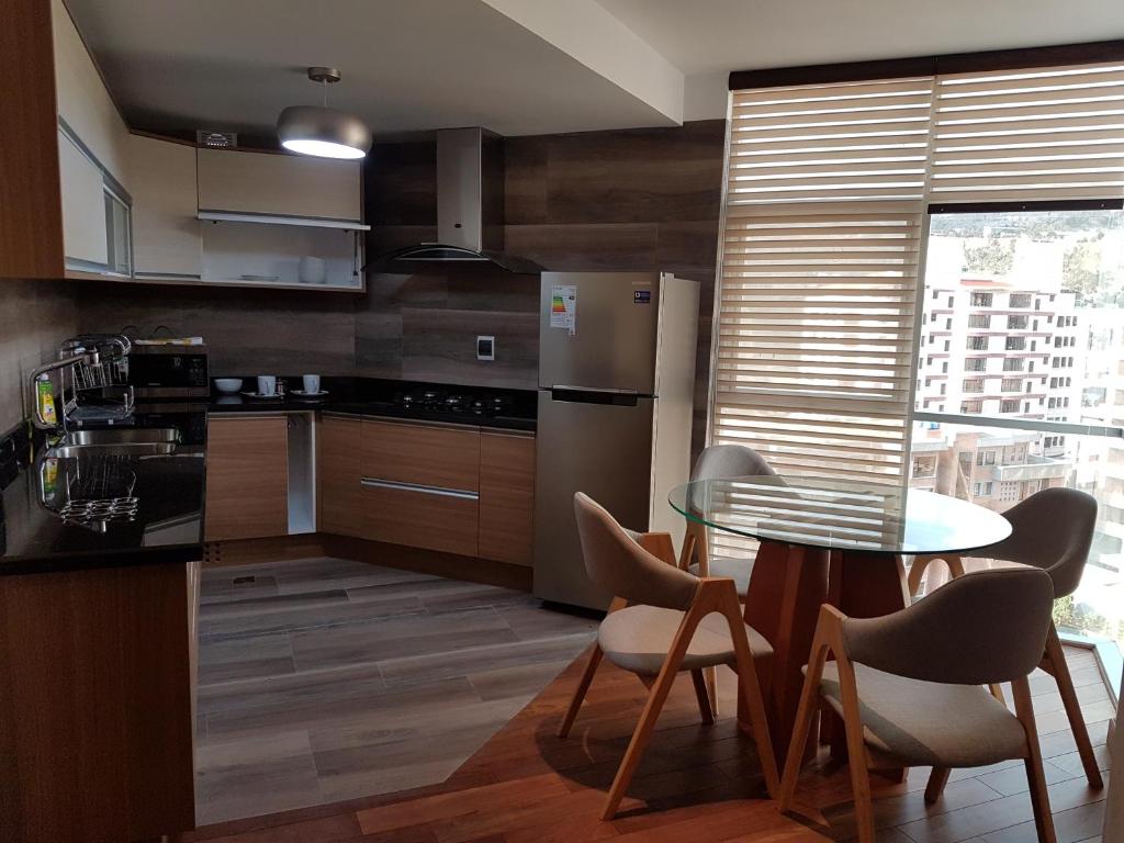 cocina con mesa, sillas y nevera en HB-3600, en La Paz