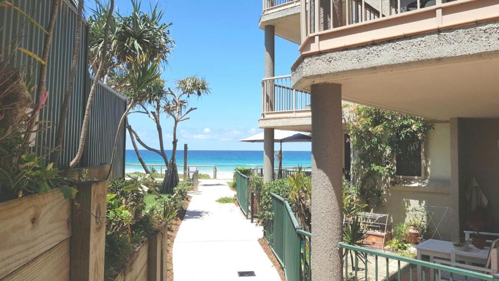 a walkway to the beach from a building at Sanctuary Beach Retreat in Gold Coast
