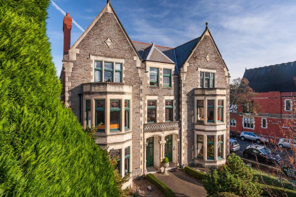 a large brick house with a turret at Lincoln House Private Hotel in Cardiff