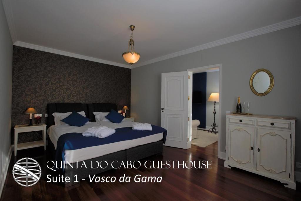 a bedroom with a bed with blue sheets and blue pillows at Quinta do Cabo Guesthouse in Sintra