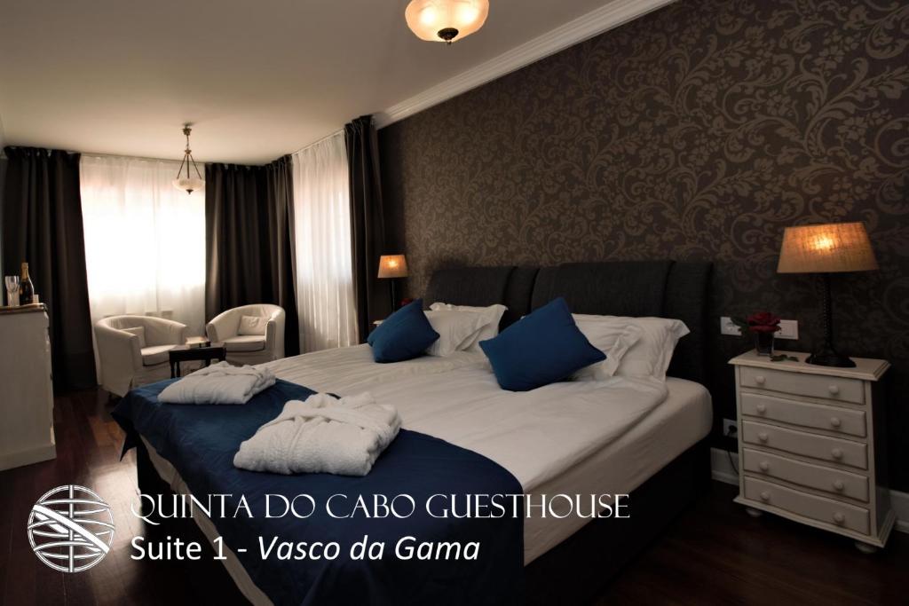 a bedroom with a bed with blue and white pillows at Quinta do Cabo Guesthouse in Sintra