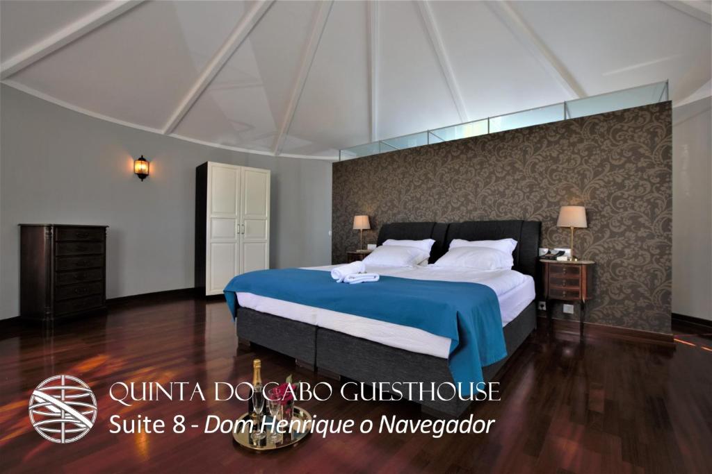 a bedroom with a large bed with a blue blanket at Quinta do Cabo Guesthouse in Sintra