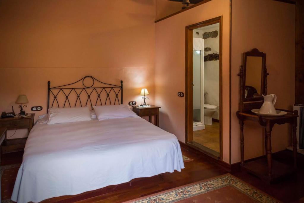 a bedroom with a large bed and a mirror at Hotel Rural Orotava in La Orotava