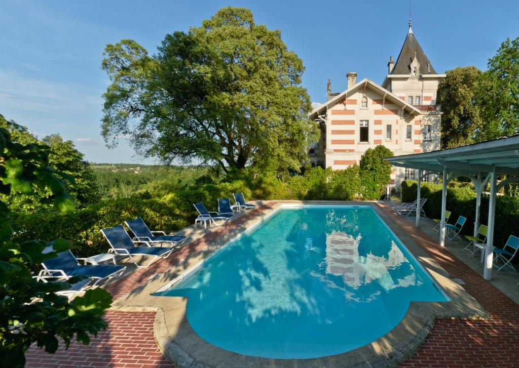 uma piscina com cadeiras e uma casa em Hôtel L'Yeuse - Les Collectionneurs em Châteaubernard