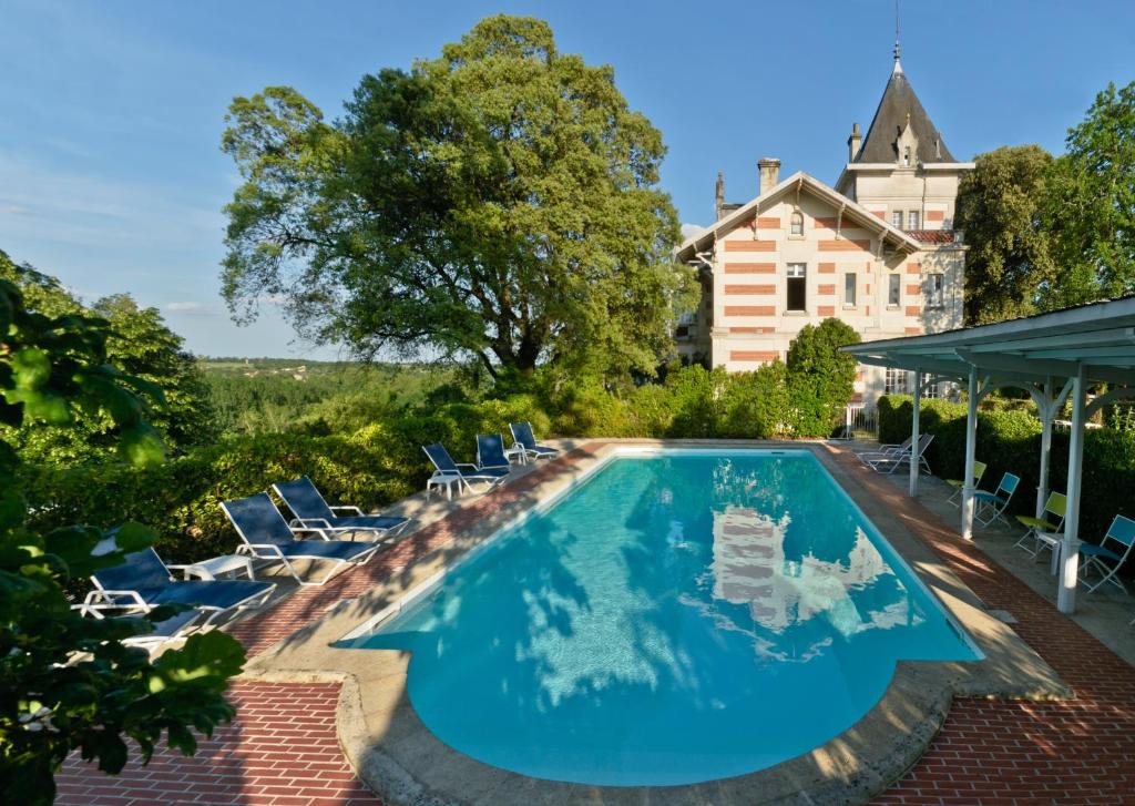 a swimming pool with chairs and a house at Hôtel L'Yeuse - Les Collectionneurs in Châteaubernard