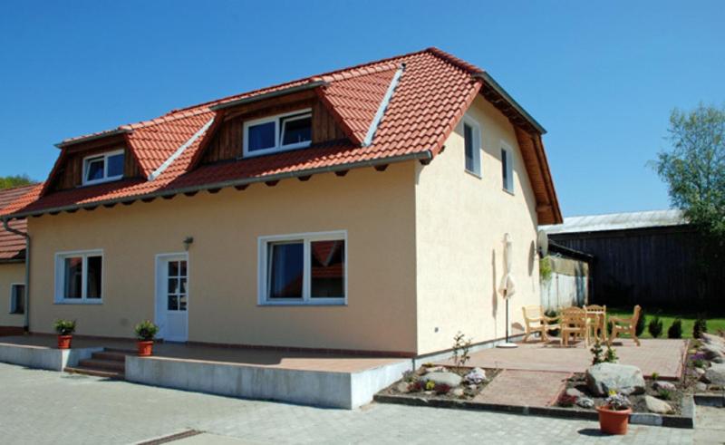 una pequeña casa con techo rojo en Ferienappartements Familie Lenz en Sehlen