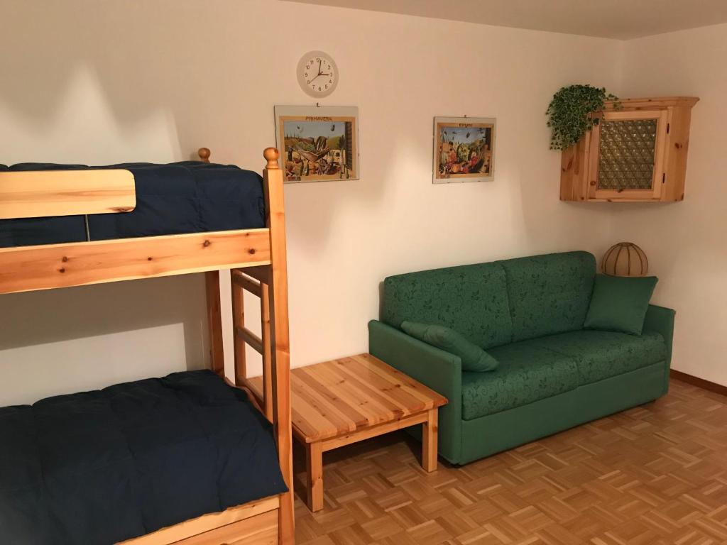 a bedroom with a bunk bed and a green couch at Gran Baita in Passo del Tonale
