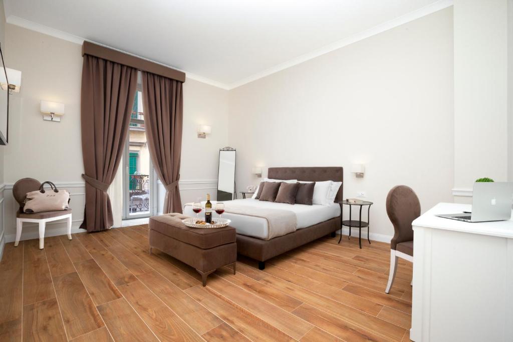 uma sala de estar com uma cama e uma mesa em La Fontanina Suites em Nápoles