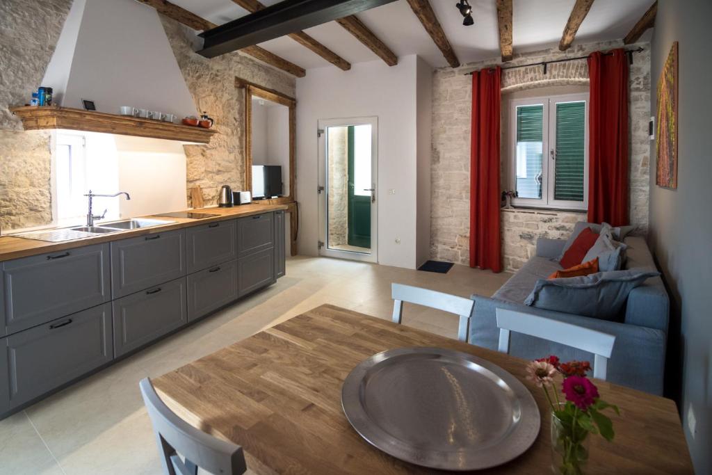 a kitchen and living room with a table and a couch at Terra Rossa in Rovinj