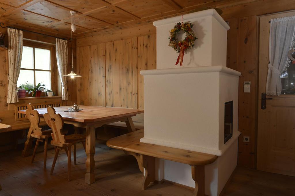 a dining room with a table and a fireplace at Agriturismo Maso Larciunei in Selva di Val Gardena