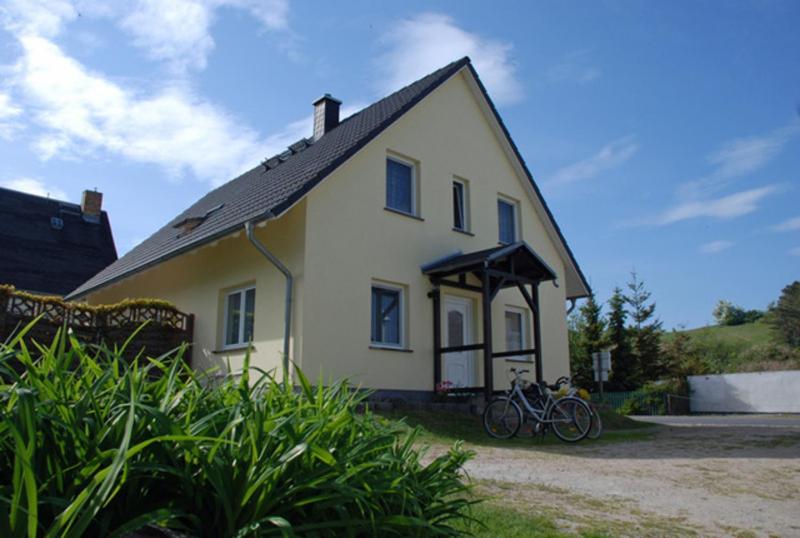 ein weißes Haus mit einem Fahrrad davor geparkt in der Unterkunft Ferienwohnungen Familie Looks in Klein Zicker